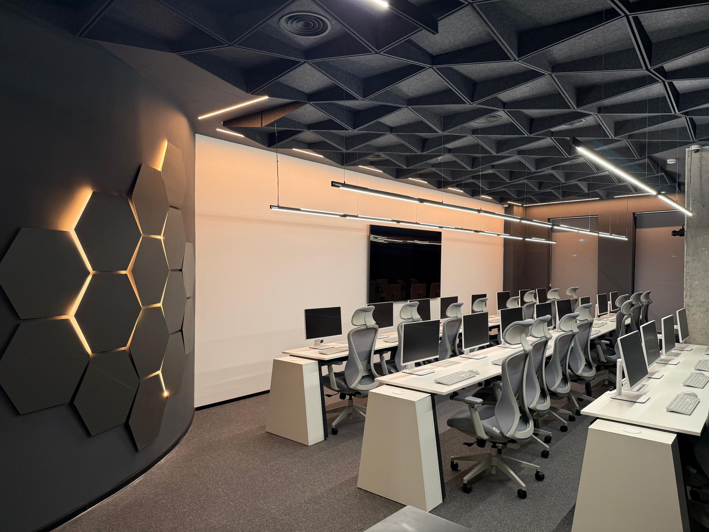 The SpotAcademy classroom in Shoham - rows of workstations, and the equipment rack behind them